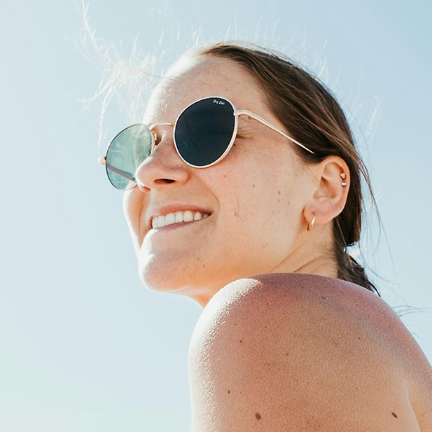 Woman wears sunglasses smiling 