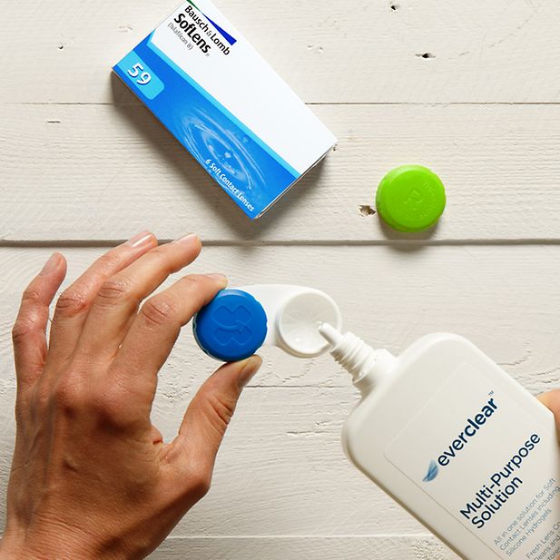 Een lensdoosje wordt gevuld met everclear REFRESH lenzenvloeistof. Een doosje Soflens lenzen is zichtbaar.