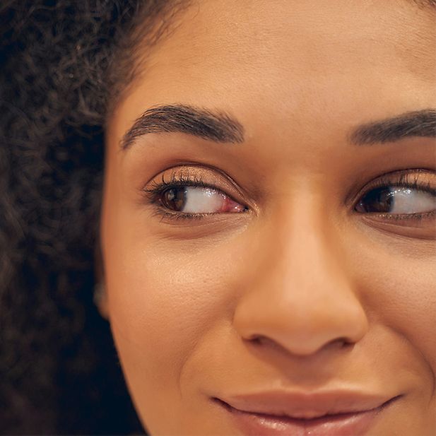 Visage d’une femme regardant sur sa droite. Elle sourit.